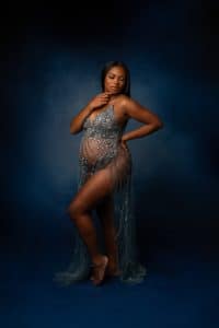 maternity photo session of woman wearing a blue dress with sparkles. Philadelphia maternity pose hands on side